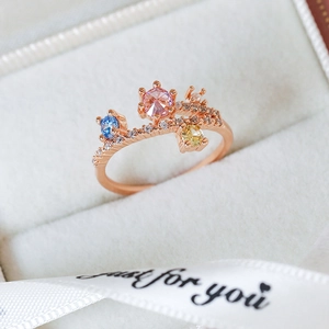 Detailed close-up of rose gold ring with three colorful heart-shaped zirconia stones