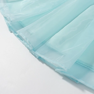 Détail des couches de tissu en organza bleu clair semi-transparent et des coutures sur la jupe