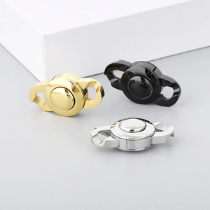 Three-color Cuban chain buckles in gold, black, and silver finishes on a grey surface