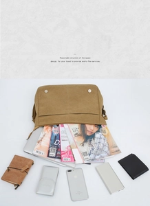 Top view of open khaki canvas messenger bag showing large interior for books and magazines
