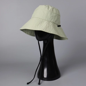 Detail of light green quick-dry sun hat showing fabric texture and adjustable wind cord