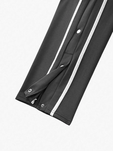 Detail of snap button hem and side stripes on high street retro jogger pants