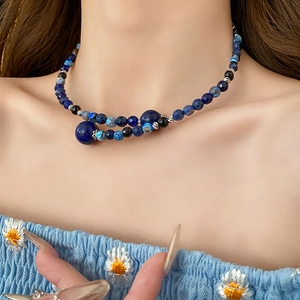 Detail view of double-layer beaded necklace featuring blue stone and black agate beads