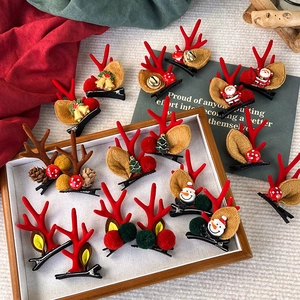 Festliche Weihnachts-Geweih-Haarklammern mit Weihnachtsmann auf einem Holztablett