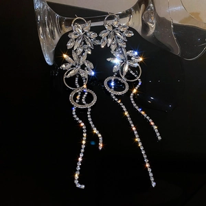 Detail view of silver floral earrings with sparkling diamond fringe on a glass base