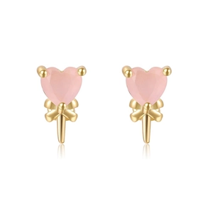 Close-up of pink heart-shaped earrings with gold bow accents and polished finish