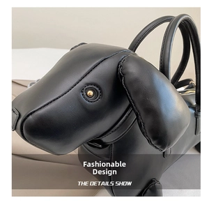 Close-up of black dachshund-shaped handbag showing leather texture and white stitching details