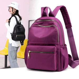 Detail of a purple nylon backpack with gold zippers and reinforced padded shoulder straps