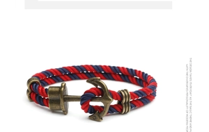 Detail of nautical anchor bracelet with red and blue braided rope and bronze finish clasp