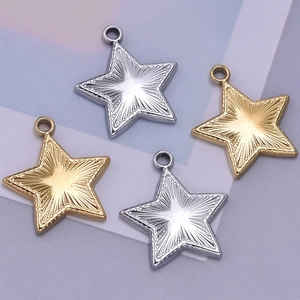 Detail of star pendants in gold and silver steel featuring engraved sunburst patterns