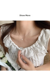 Delicate zircon pendant necklace shown on a model neck with a white lace dress