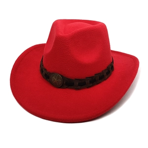 Macro detail of red wool cowboy hat with leather braided band and metallic star badge