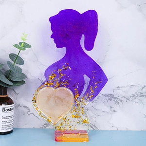 Dettaglio cornice silhouette donna incinta in resina con foglia oro e glitter viola