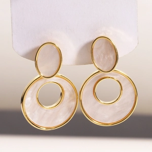 Detailed macro view of vintage geometric 18K gold plated earrings with cream resin inlay