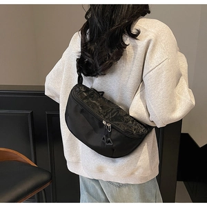 Detail of adjustable thick strap and dual zipper closure on marble pattern chest bag