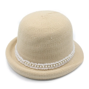 Detailed view of beige knit cloche hat with white lace trim and elegant pearl beads