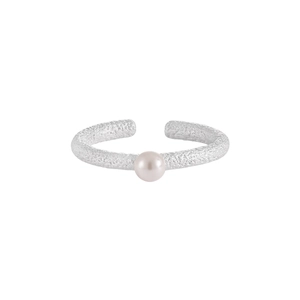 Macro detail of silver textured ring featuring a white pearl inlay on a matte surface