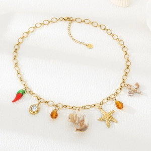 Détail du collier en acier inoxydable avec coquillages dorés et pendentifs piment