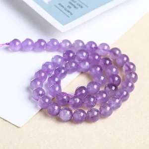 Macro view of purple amethyst round beads with natural ice crack texture and polished finish