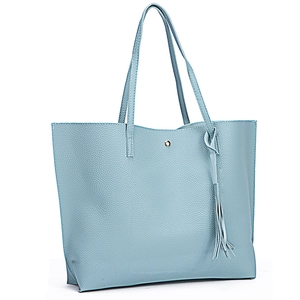 Detail of light blue lychee pattern leather tote bag with stylish side tassel decor