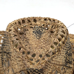 Detail of hand-woven straw cowboy hat showing intricate hollow texture and natural fiber patterns
