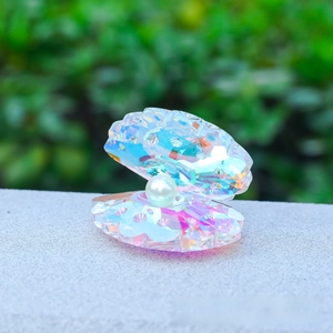 Macro shot of an iridescent crystal shell ornament featuring a single white faux pearl