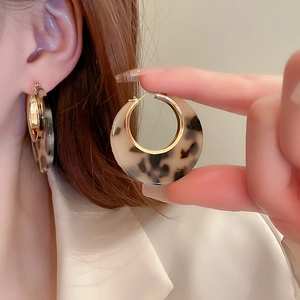 Close-up of leopard print hoop earrings with gold plating and tortoiseshell texture