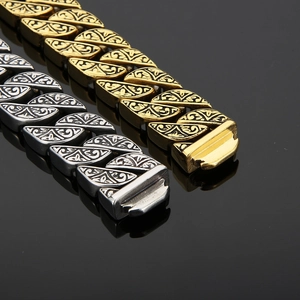 Macro detail of engraved vintage scroll patterns on gold and silver cuban chain bracelets