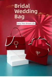 Detail of red bridal velvet handbags with pearl chains and elegant metal hardware