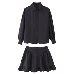 Detail of black long sleeve lapel shirt and ruffled skirt set shown in flat lay