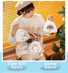 Plush penguin and polar bear charms displayed in a cozy festive gift box setting