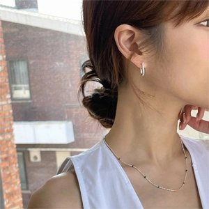 Minimalist 925 sterling silver U-shaped horseshoe stud earrings worn by a model