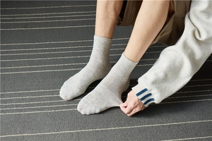 Detail showing the elastic cuff of gray mid-calf cotton socks for a comfortable fit