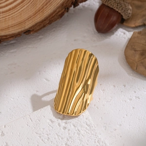 Detailed close-up of 18K gold stainless steel ring with organic wave texture on stone