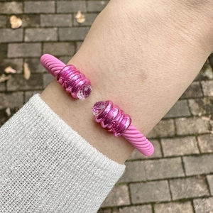 Rosa mattes Kabelarmband mit Perlen und Kristallen am Handgelenk einer Frau
