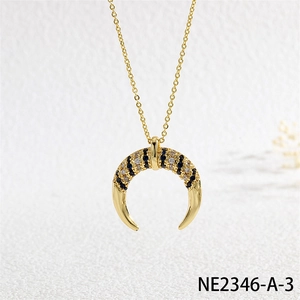 Macro shot of gold crescent moon pendant with blue and white pavé cubic zirconia