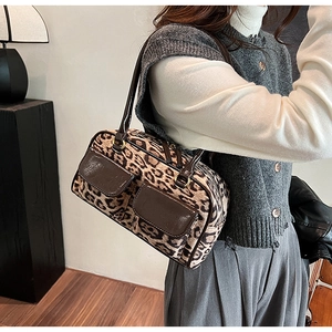 Detail of leopard print suede shoulder bag with leather pockets worn by a model