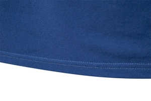 Detailed macro view of the double-stitched hem and navy blue mesh texture on the polo shirt