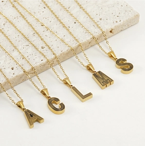 Détail de pendentifs lettres en acier inoxydable plaqué or 18k avec texture concentrique noire