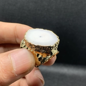 Detalle de anillo martillado bañado en oro de 14K con piedra de cristal blanco natural