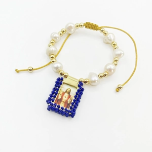 Detailed view of religious handmade bracelet with natural pearls and Jesus image pendant