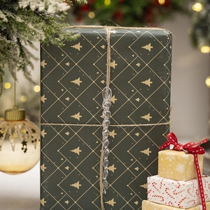 Detail shot of a transparent acrylic icicle ornament hanging by a gift box