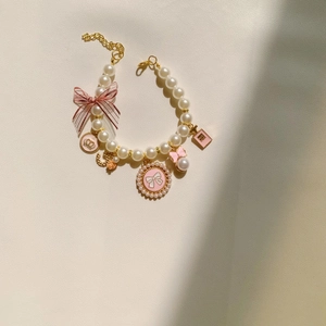 Elegant pet pearl necklace with pink ribbon and fashion pendants on leather background