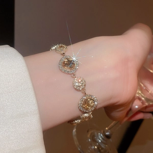 Detailaufnahme des goldfarbenen Armbands mit champagnerfarbenen ovalen Kristallen