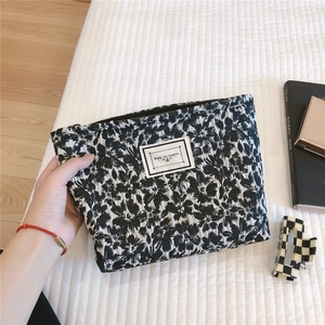 Macro shot of textured floral vanity bag with black and white bow and logo label