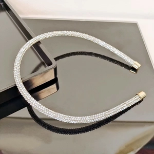 Close-up of sparkling rhinestone hair hoop with silver crystals and gold metal ends