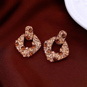 Dettaglio di orecchini vintage color oro champagne con cristalli su velluto rosso