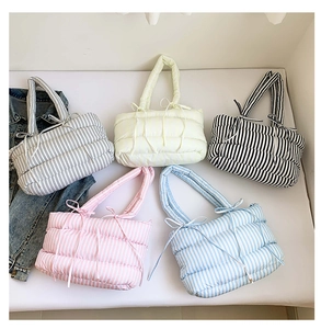 Vue à plat de sacs cabas matelassés colorés à rayures avec poignées à nœuds
