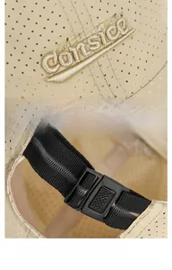 Detail of embroidered logo and adjustable plastic strap on breathable beige baseball cap