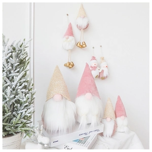 Detailed view of pink velvet Santa gnome dolls and plush reindeer holiday decorations
